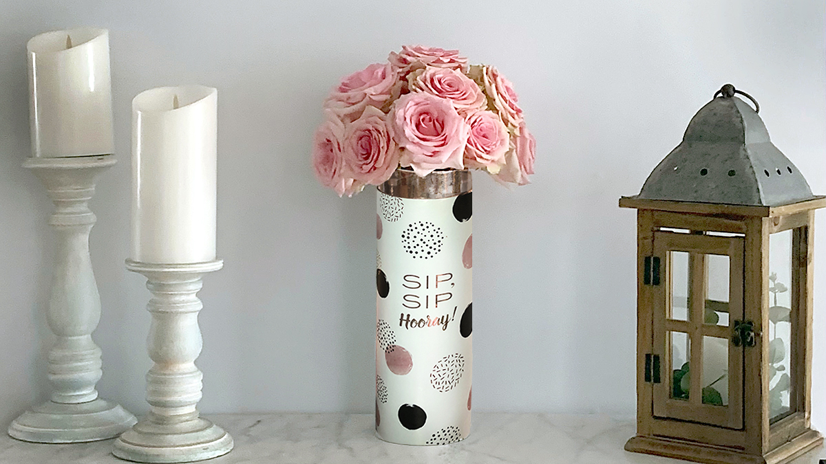 a photo of roses and rosé with a wine carrier vase displayed on a shelf