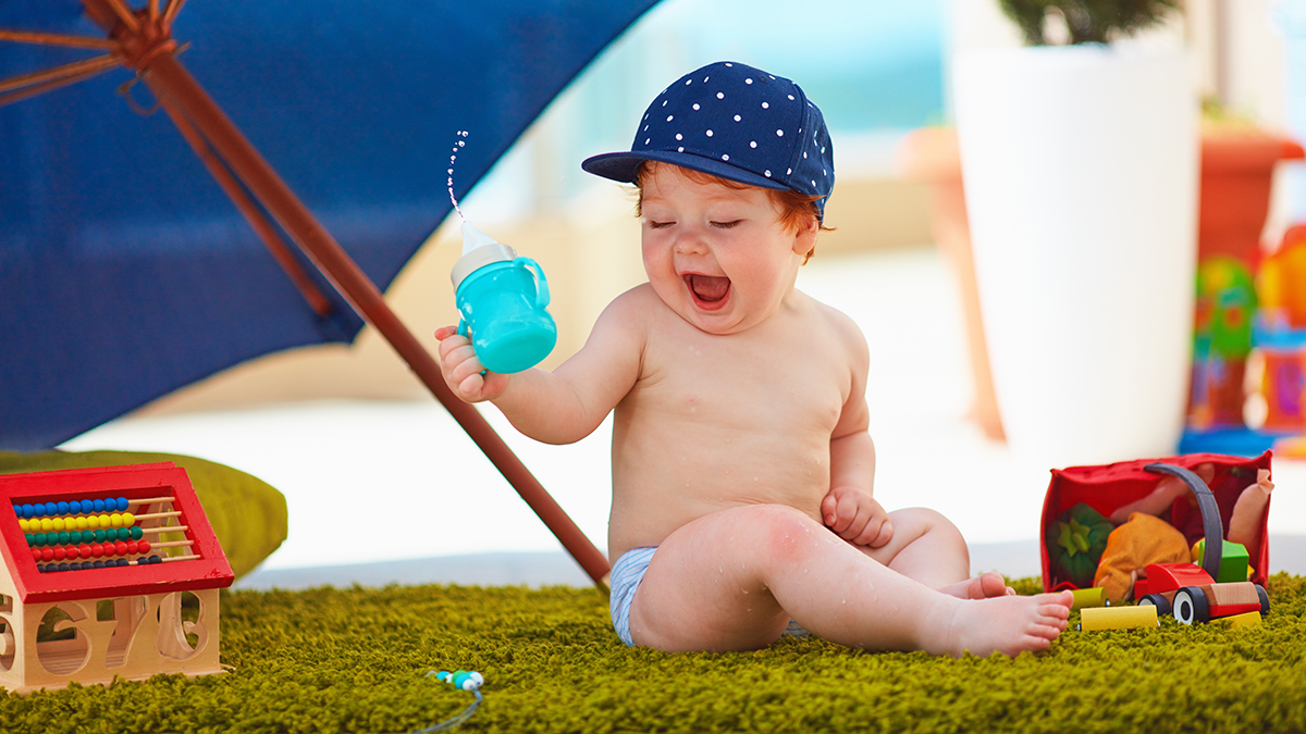 cumpleaños de agosto con un bebé jugando alegremente bajo un paraguas