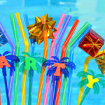 august birthdays with party decorations and colored tubules on the swimming pool background