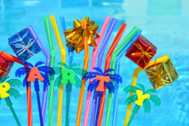 august birthdays with party decorations and colored tubules on the swimming pool background
