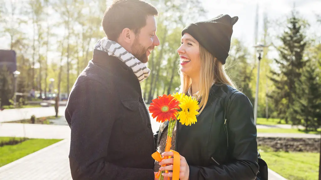 Photo of flowers for a date with couple with flower at the park