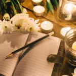 how to write an obituary with a notebook among candles