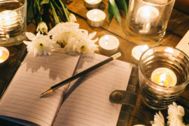 how to write an obituary with a notebook among candles
