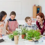 classroom plants with group of school kids with teacher planting herbs