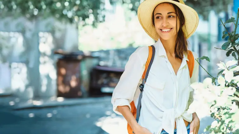 coastal grandmother with portrait woman in straw hat and white shirt walking