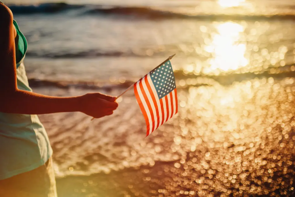 Photo of a woman holding an American Flag to celebrate workers and Labor Day.