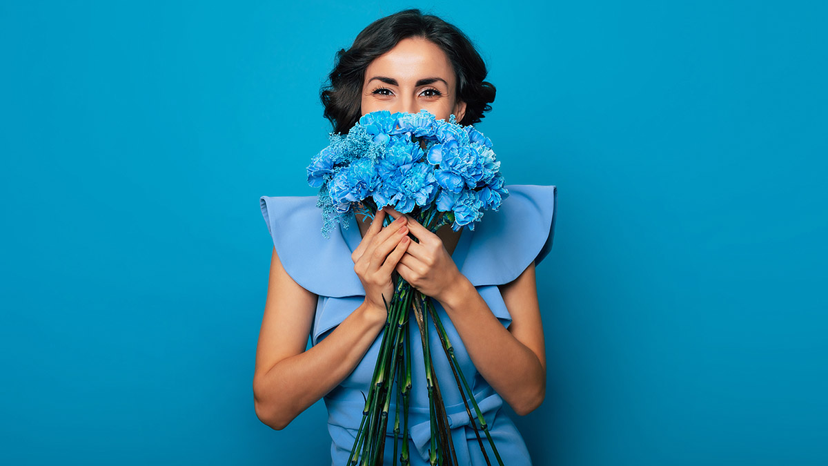 https://www.flowers.com/blog/wp content/uploads///woman holding blue flowers