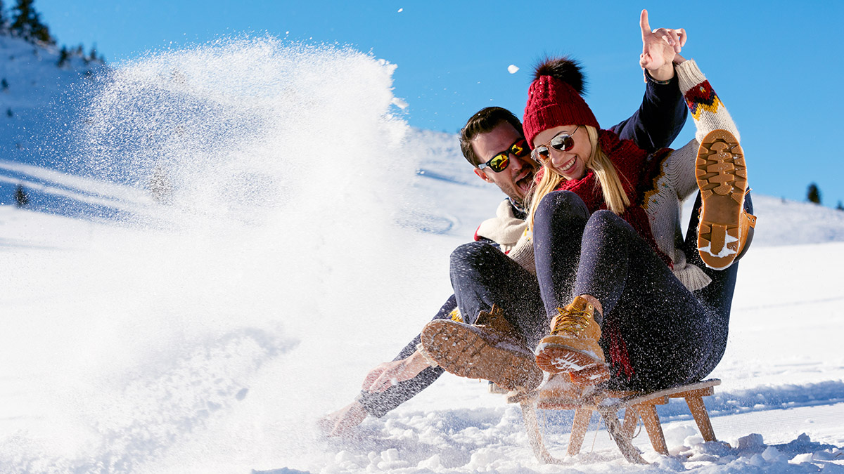 cold weather date ideas with couple sledding