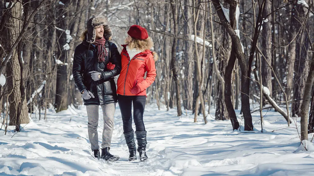 cold weather date ideas with couple walking through woods