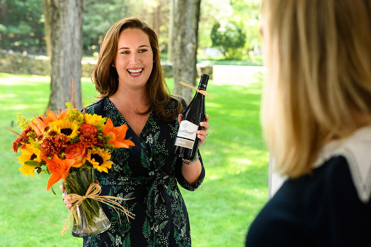 dinner guest etiquette with guest bringing wine and flowers