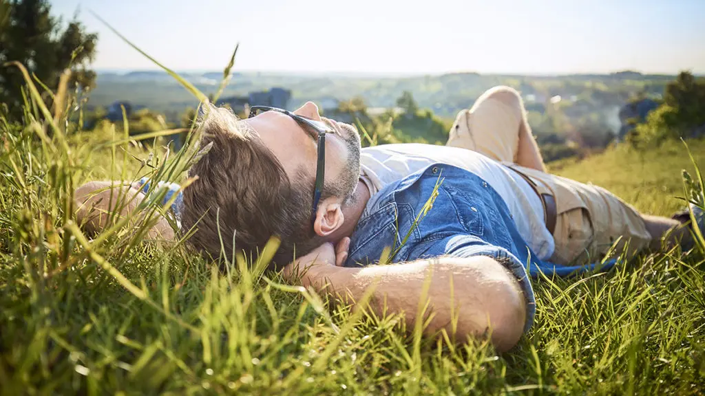 Why setting goals is important with man relaxing lying outside