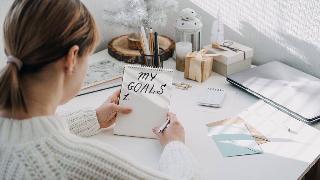 Why setting goals is important with woman writing down goals