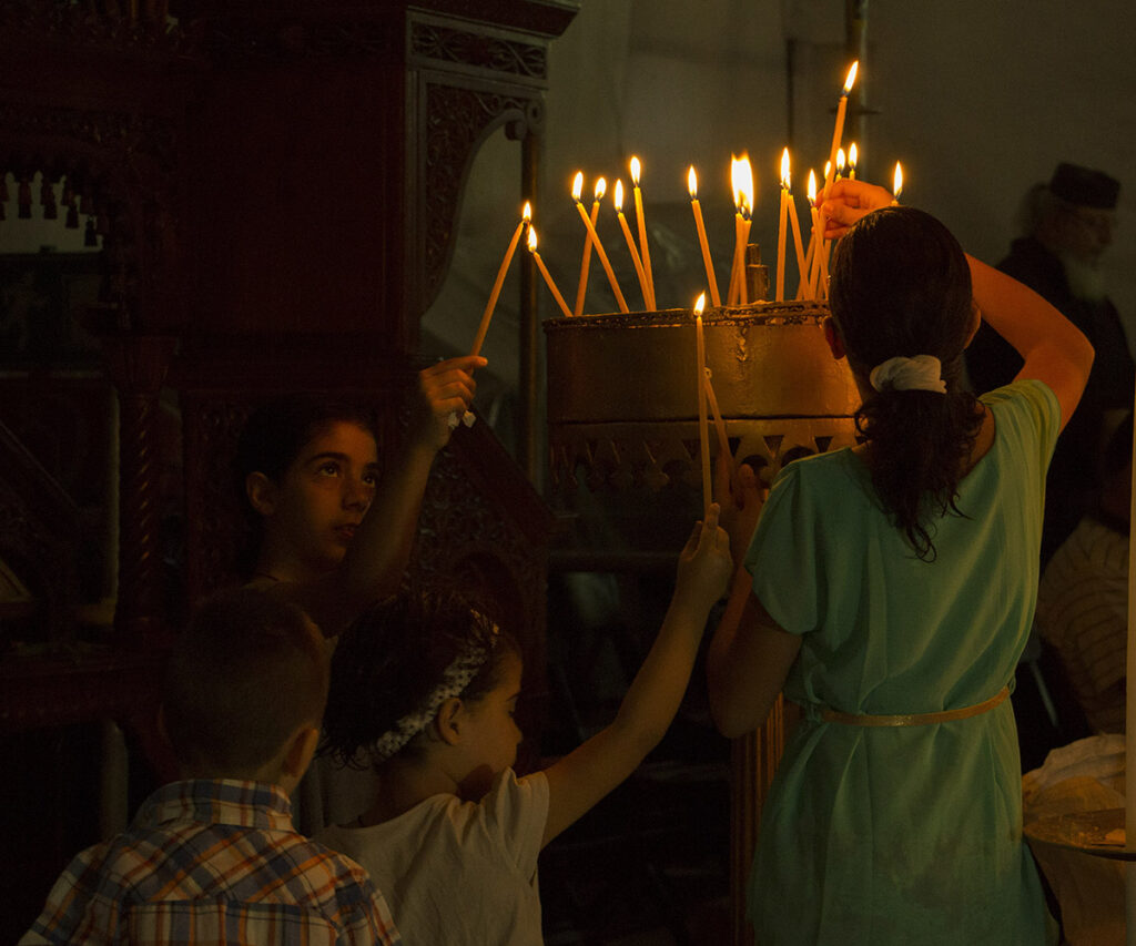 Navidad por el mundo con cuatro niños rezando en la Iglesia de la Natividad en Belén