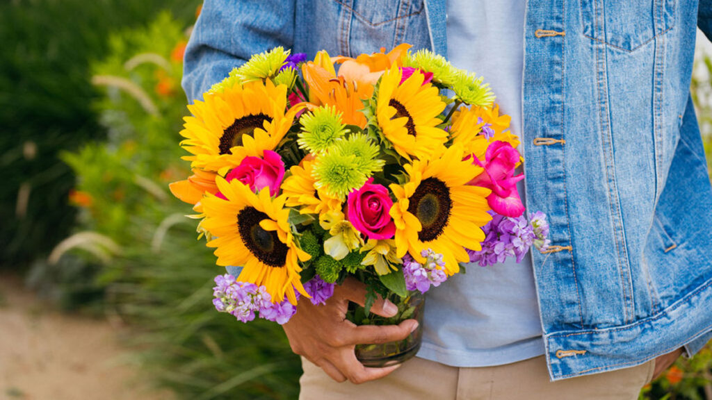 Tendencias de flores con hombre sosteniendo flores de colores.