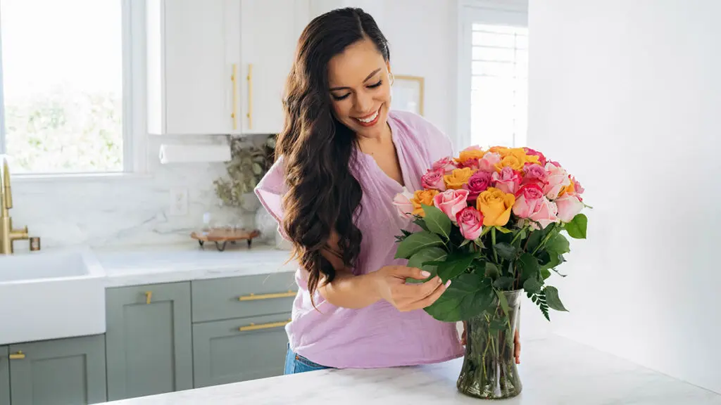 flowers as a gift with woman displaying flowers in kitchen