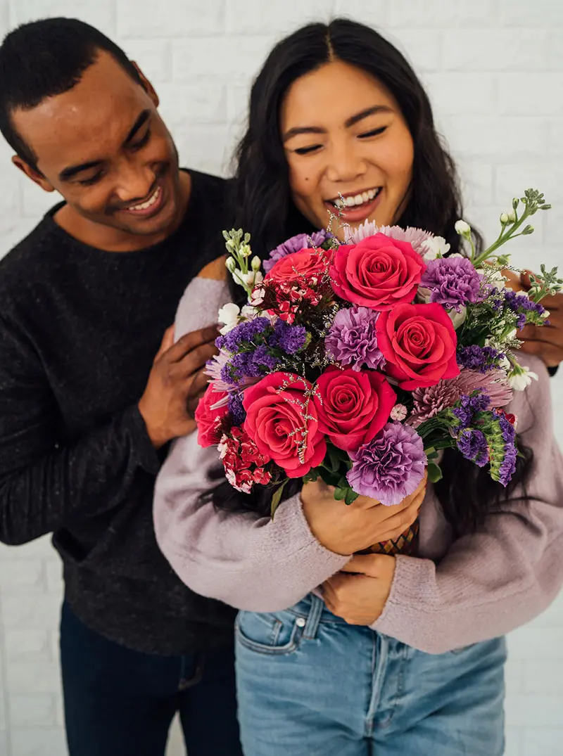 flowers as a gift with woman getting flowers from boyfriend
