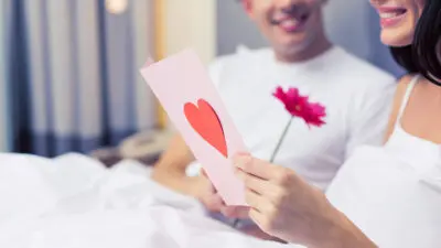 How to write a love letter with a woman reading a love letter with a man smiling at her.