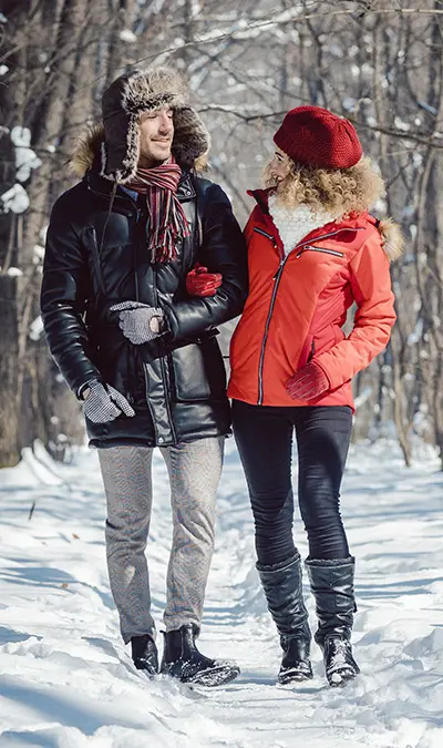 hygge with couple taking walk through woods in winter