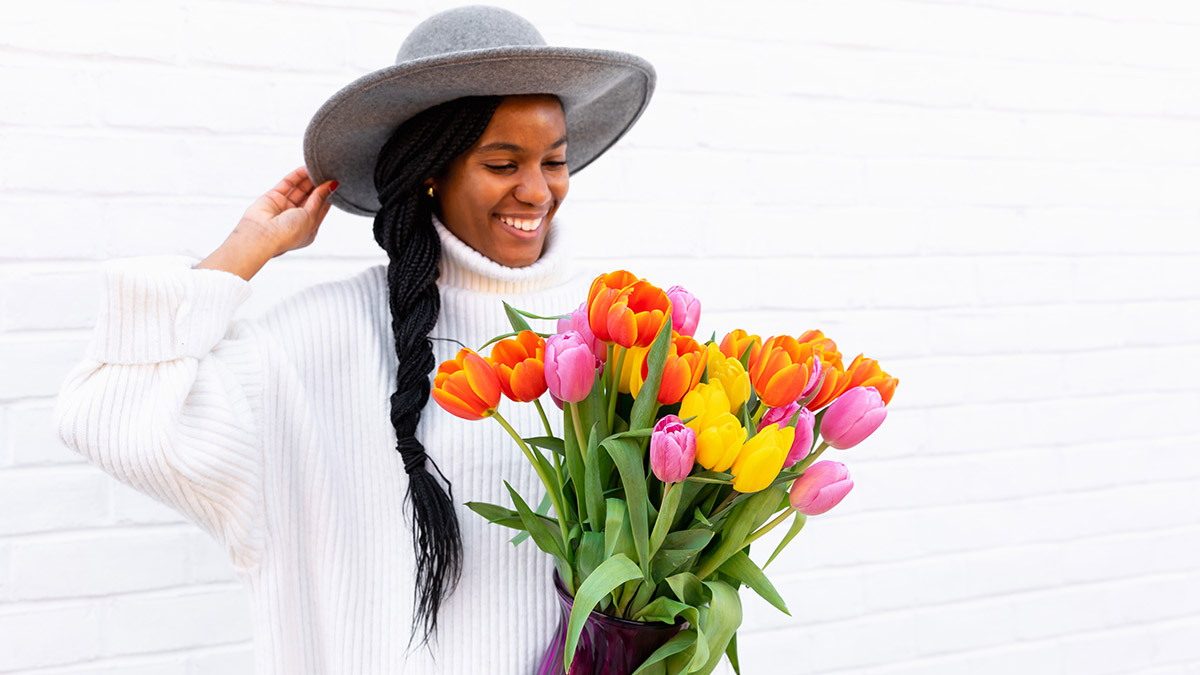 Regalos de cumpleaños para Aries con una mujer sosteniendo un ramo de tulipanes