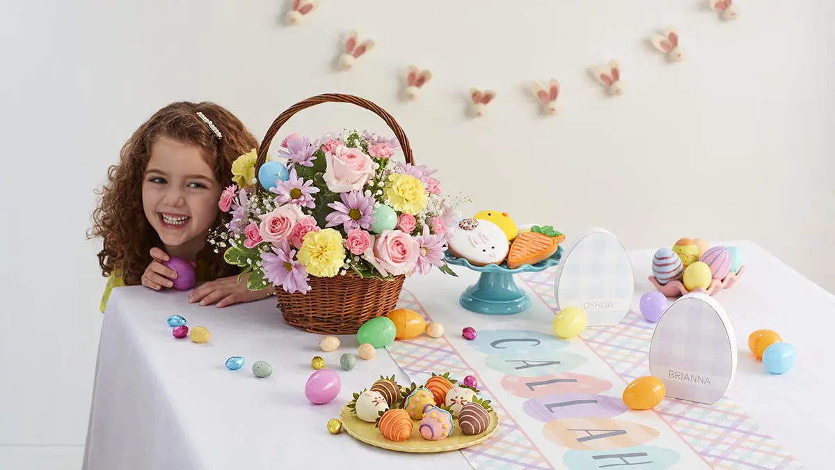 búsqueda de huevos de pascua con chicas escondidas detrás de una canasta de flores de pascua