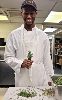 Foto de Manny Irick en la cocina del restaurante.  Fue contratado a través de Smile Farms, que ayuda a crear empleos para personas con discapacidades.