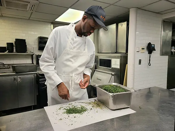 Photo of Manny Irick in the kitchen of restaurant. He was hired through Smile Farms, which helps create
jobs for people with disabilities