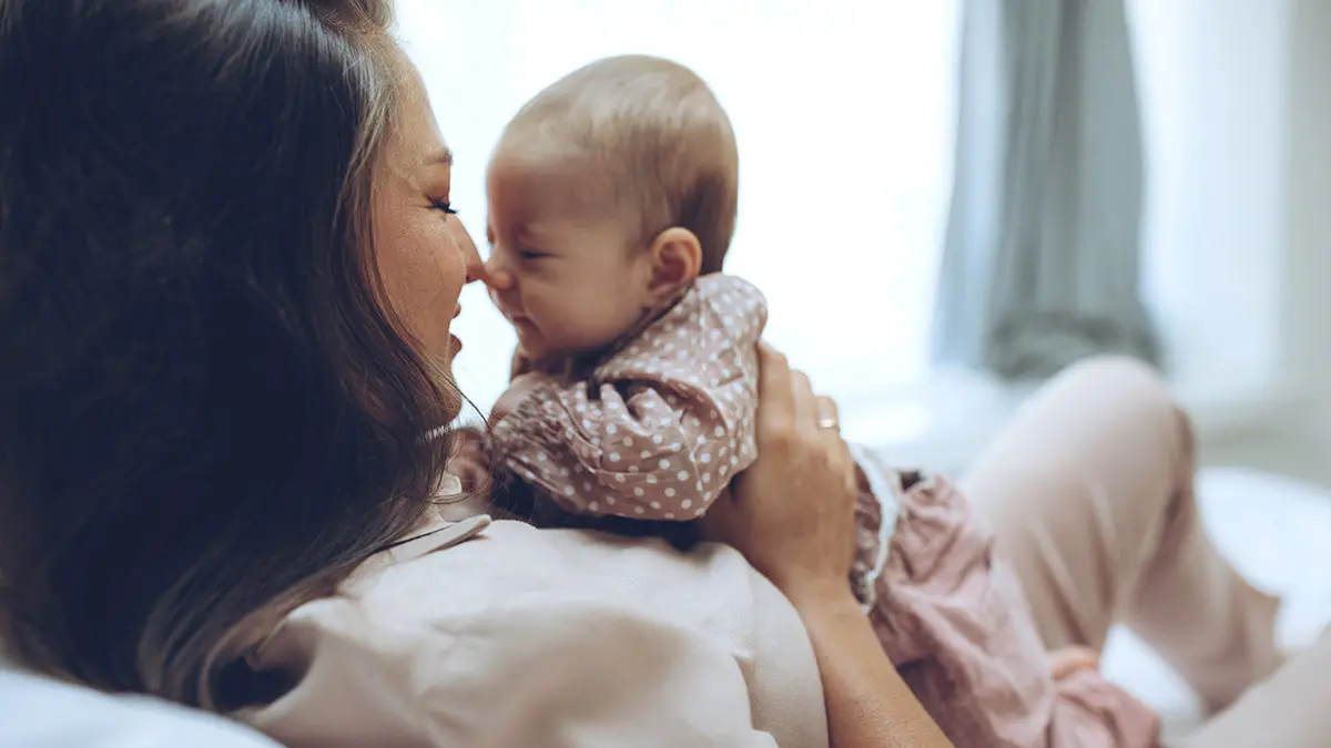 Regalos del Día de la Madre para mamás primerizas donde la mamá se acurruca con el bebé