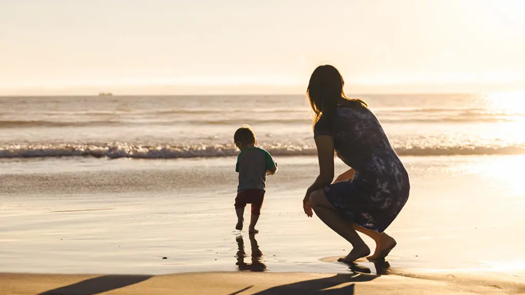 motherhood quotes with mother watching son run on beach