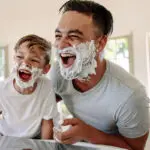 Father and son having fun while shaving in bathroom