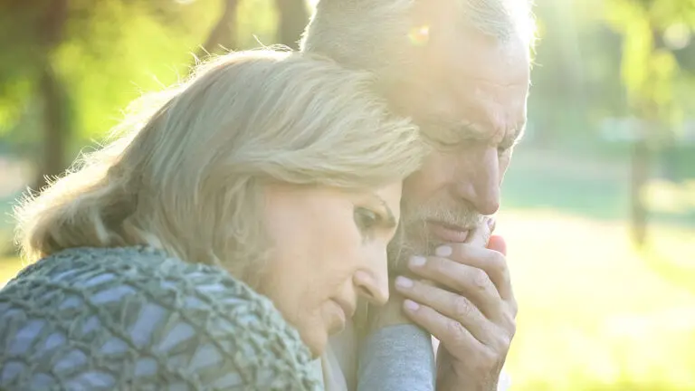 Sad senior wife embracing crying husband, relative loss, grief a