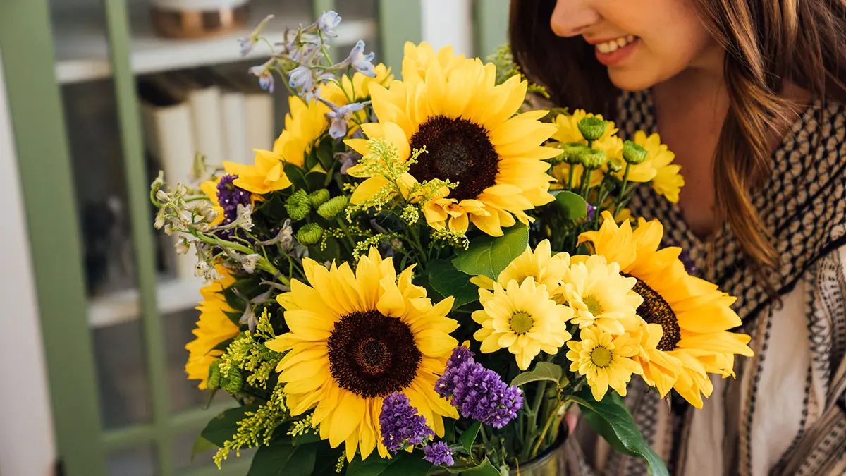 birthday gifts for leo woman holding sunflower bouquet
