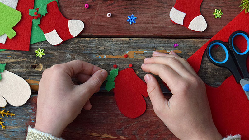 Hacer juguetes navideños hechos a mano con fieltro con tus propias manos.  Concepto de bricolaje para niños.  Producción de adornos para árboles de Navidad o tarjetas de felicitación.  Paso .  Decora el juguete