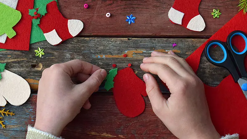 Making of handmade christmas toys from felt with your own hands. Children's DIY concept. Making xmas tree decoration or greeting card. Step . Decorate the toy