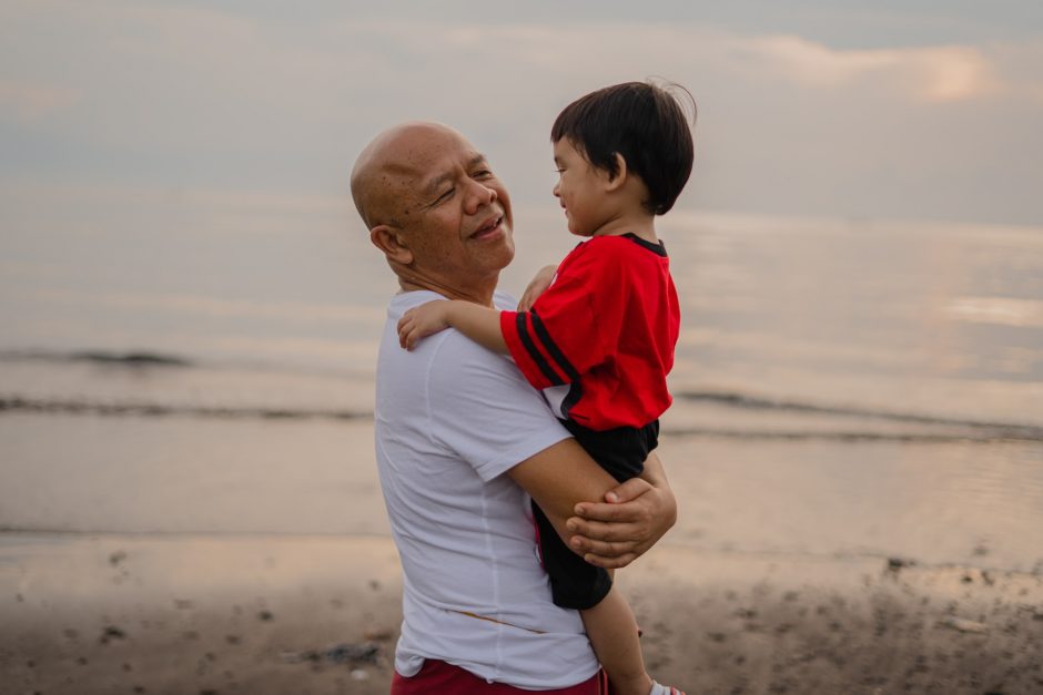 grandparents day grandfather holding grandson on beach