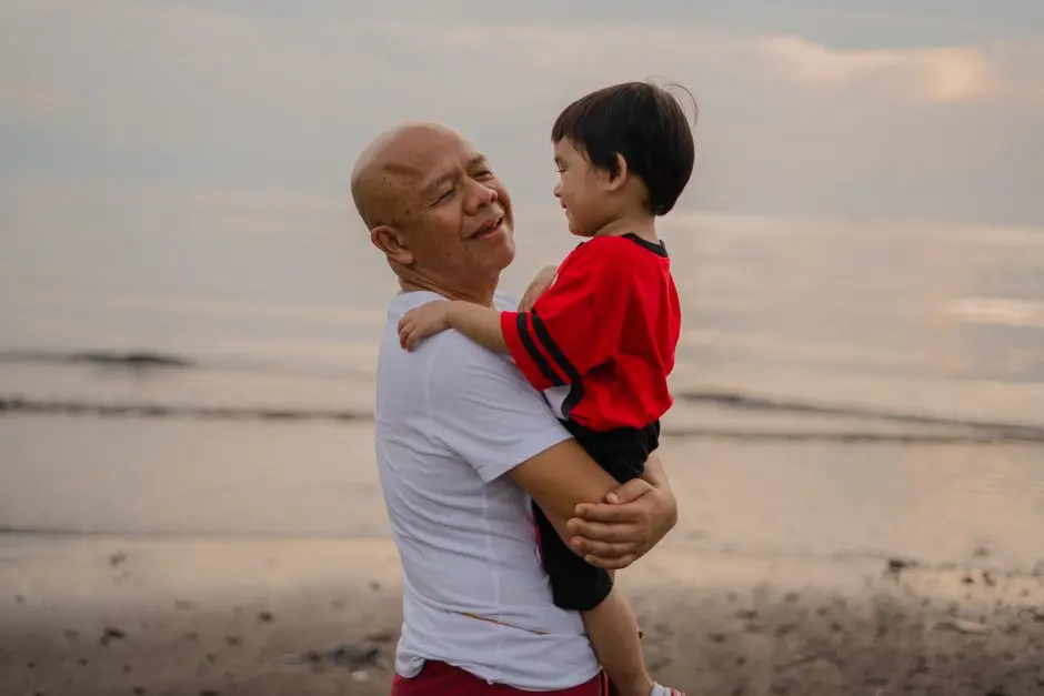 grandparents day grandfather holding grandson on beach