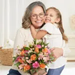 grandparents day grandmother hugging granddaughter with flowers