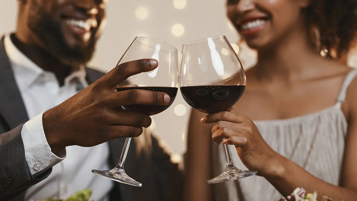 Close up of african couple toasting with red wine