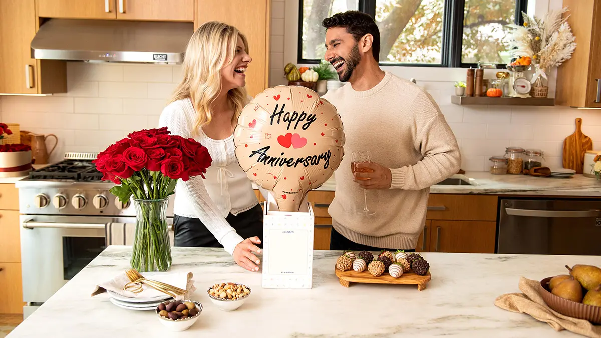 anniversary gift guide couple celebrating in kitchen