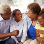 Grandparents and their young grandchildren relaxing at home