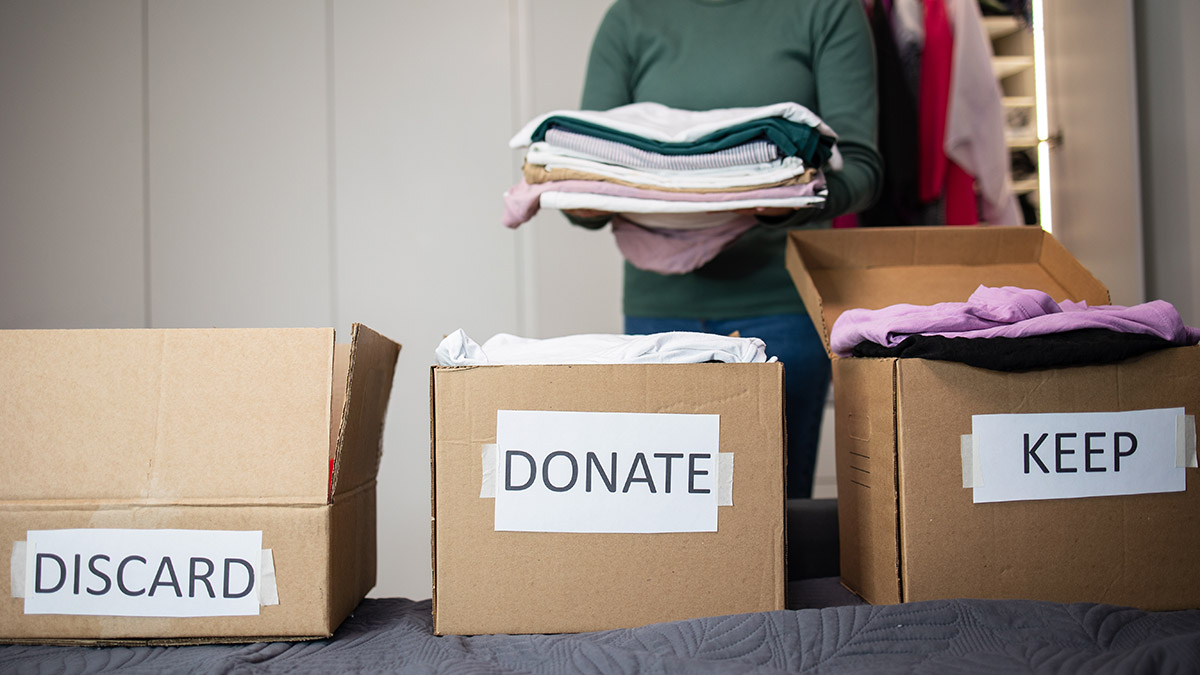 A woman packs clothes in a box for donating clothes