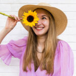 sunflower symbolism woman holding sunflower in front of face