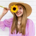 sunflower symbolism woman holding sunflower in front of face