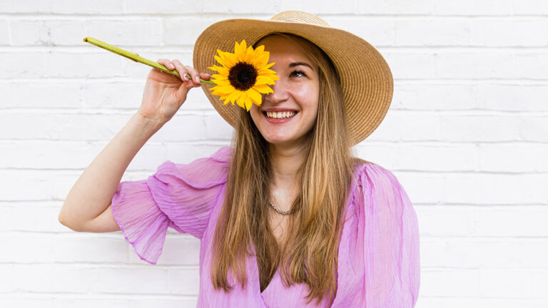 sunflower symbolism woman holding sunflower in front of face