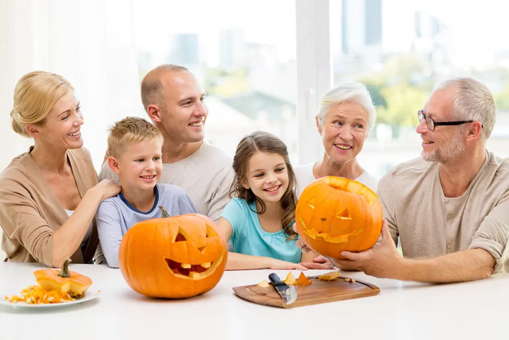 happy family sitting with pumpkins at home