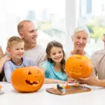 happy family sitting with pumpkins at home