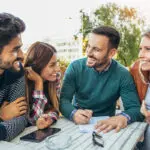 Group of four friends having fun a coffee together. Two women an