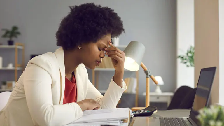 signs of burnout with Frustrated woman keeping eyes closed and massaging nose