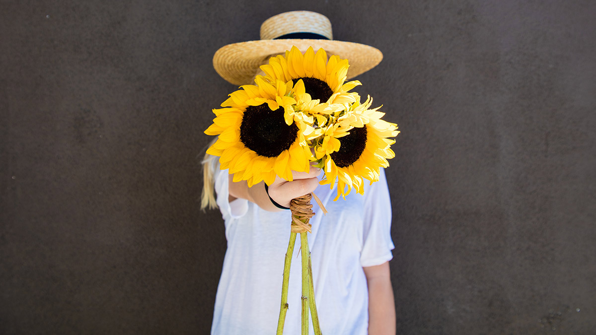 sunflower quotes women holding sunflowers in front of face