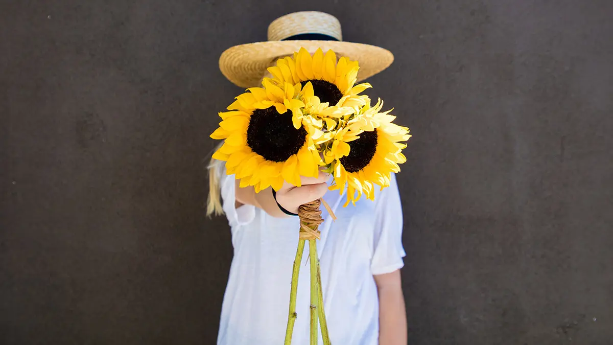 sunflower quotes women holding sunflowers in front of face