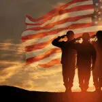 USA army soldiers saluting on a background of USA flag. Greeting card for Veterans Day, Memorial Day, Independence Day.